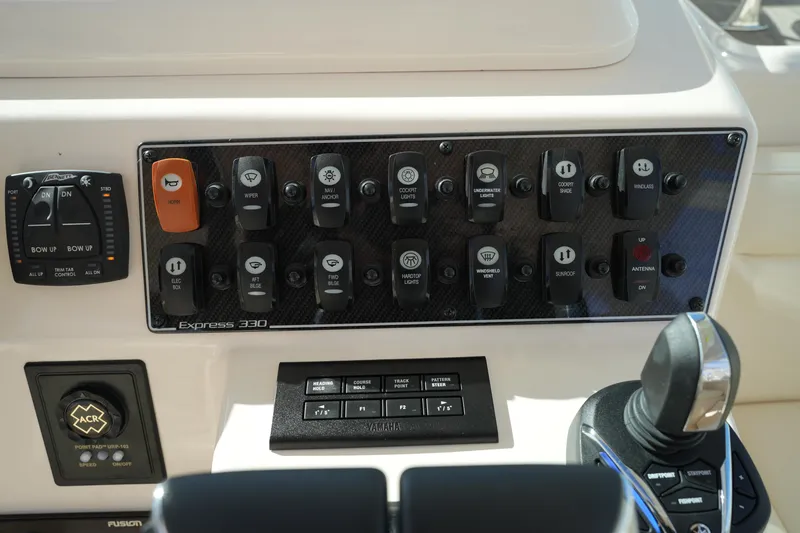 Slide: The Image of Control panel of 2024 Grady-White Express 330 boat with various switches and controls. - 51