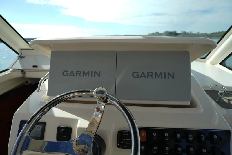 Slide: The Image of 2024 Grady-White Express 330 helm with dual Garmin displays and steering wheel. - 57