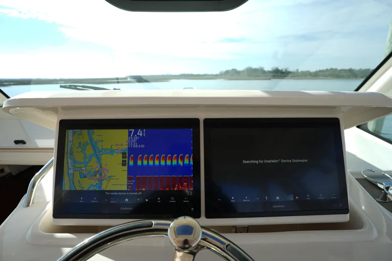 Slide: The Image of 2024 Grady-White Express 330 helm with dual Garmin displays, showcasing navigation and device search. - 58