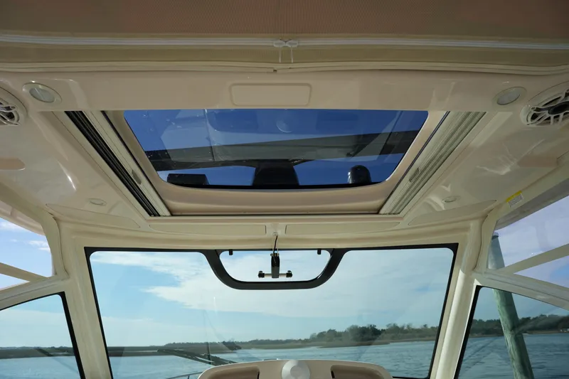Slide: The Image of 2024 Grady-White Express 330 boat interior with sunroof and scenic water view. - 59