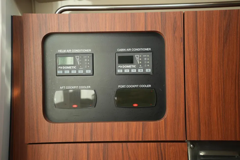 Slide: The Image of 2024 Grady-White Express 330 air conditioning and cooler controls on wood panel. - 61