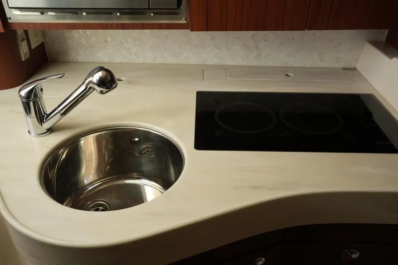 Slide: The Image of 2024 Grady-White Express 330 kitchen with sink and stovetop, featuring modern design. - 62