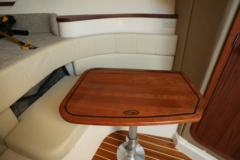 Slide: The Image of 2024 Grady-White Express 330 cabin with wooden table and cushioned seating. - 66