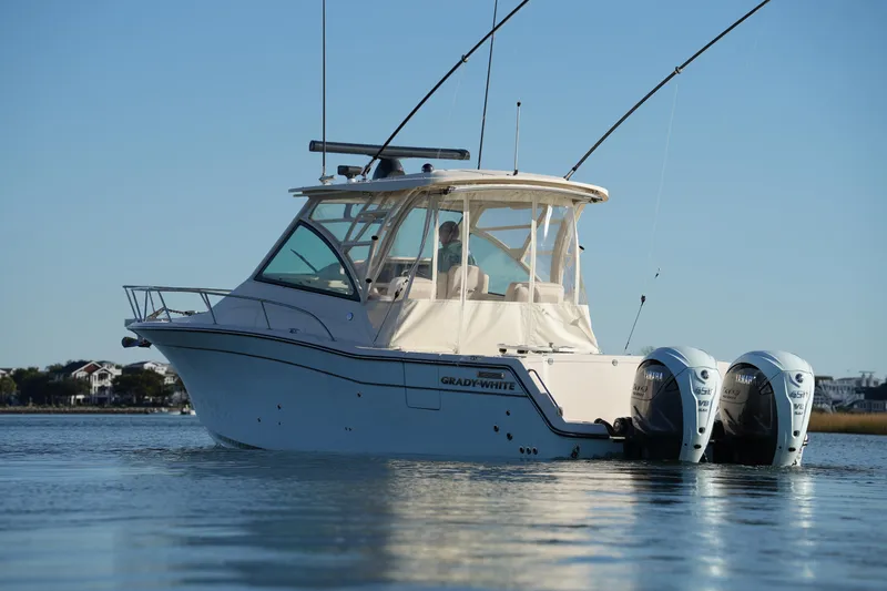 Slide: The Image of 2024 Grady-White Express 330 boat on calm water with dual Yamaha engines. - 7