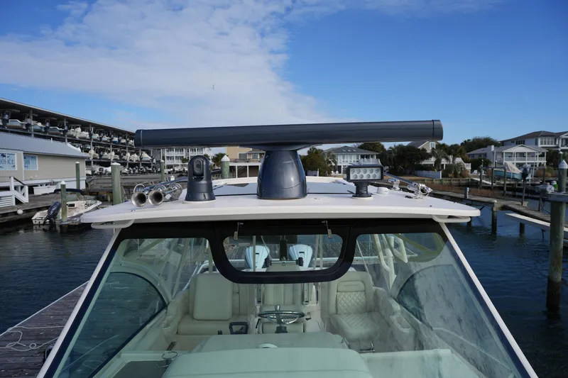 Slide: The Image of 2024 Grady-White Express 330 boat docked, showcasing radar and navigation equipment. - 76