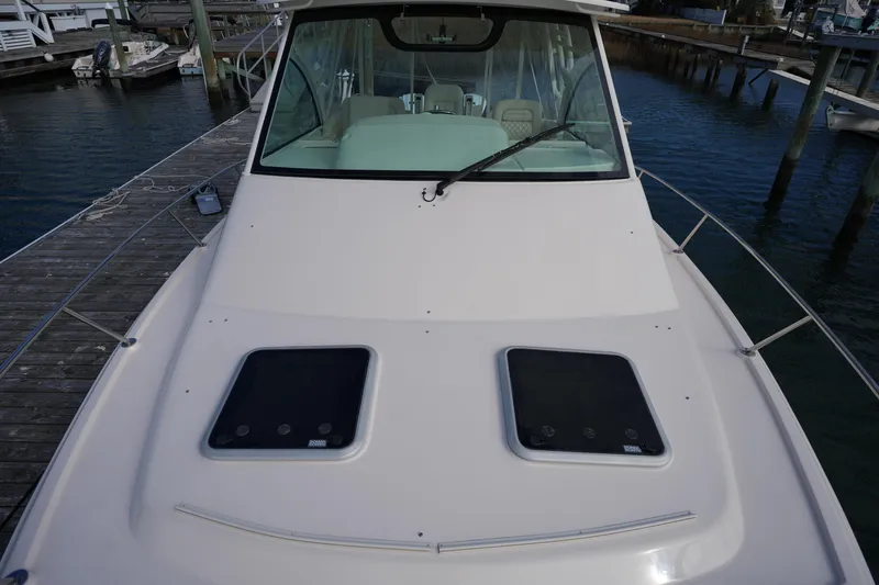 Slide: The Image of 2024 Grady-White Express 330 boat docked, showcasing front deck and cabin. - 78