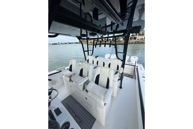 Slide: The Image of 2020 SeaHunter 41 CTS boat docked near palm trees and a modern house. - 14