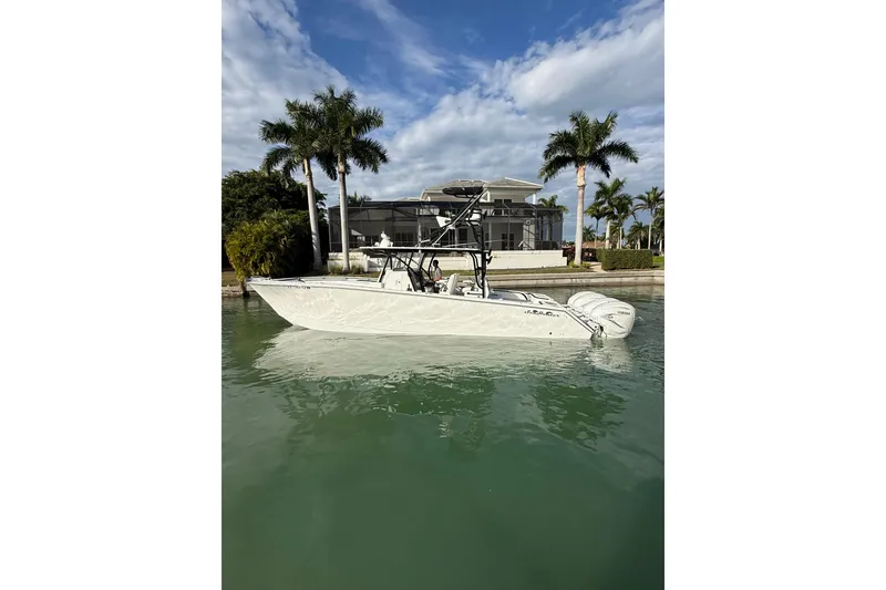 Slide: The Image of 2020 SeaHunter 41 CTS boat with triple Yamaha engines docked near a luxury waterfront home. - 4