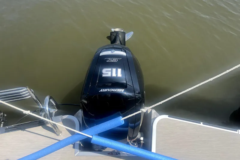 Slide: The Image of Outboard motor on 2025 Harris Breeze 230 pontoon boat, docked on calm water. - 10