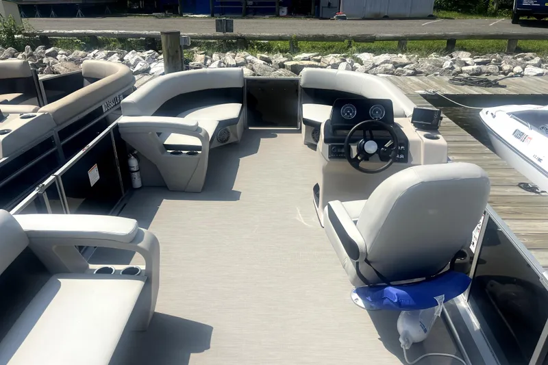 Slide: The Image of Interior view of 2025 Harris Breeze 230 pontoon boat with modern seating and steering console. - 2
