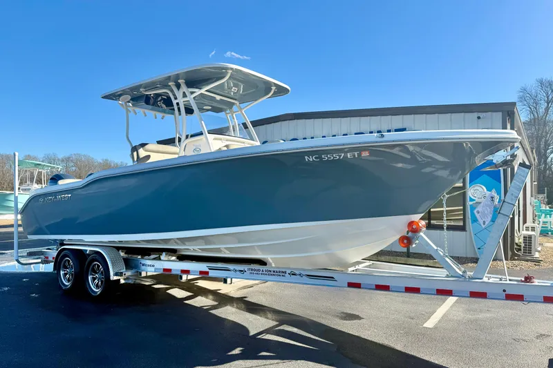 The Image of 2021 Key West 263 FS boat on trailer, parked outdoors under clear blue sky. - 1