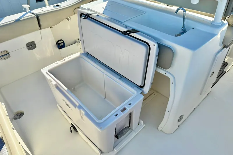 Slide: The Image of 2021 Key West 263 FS boat interior with open storage compartment and sink. - 28