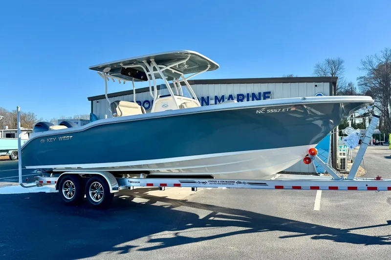 Slide: The Image of 2021 Key West 263 FS boat on trailer, parked outside marine dealership. - 4