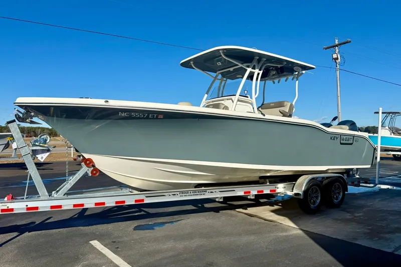 Slide: The Image of 2021 Key West 263 FS boat on trailer under clear blue sky. - 5