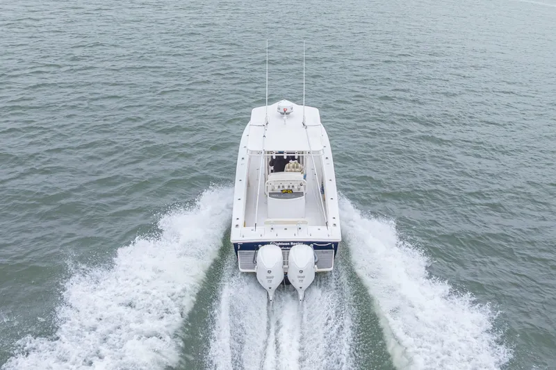 Slide: The Image of 2008 Jupiter 31 FS boat cruising on open water, rear view with twin engines. - 17