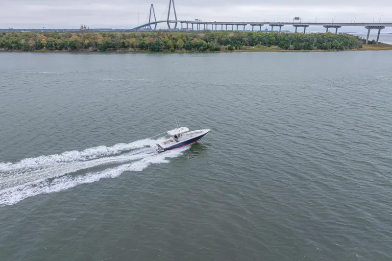 Slide: The Image of 2008 Jupiter 31 FS boat cruising on a river near a bridge and lush shoreline. - 20