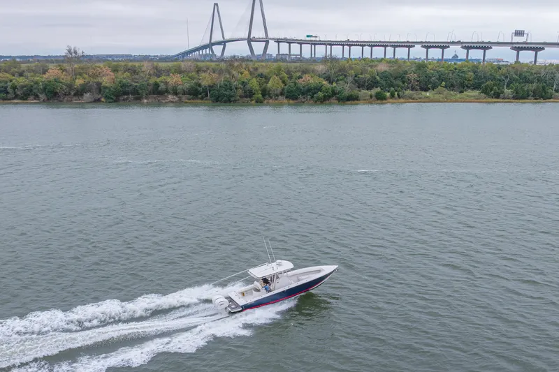 Slide: The Image of 2008 Jupiter 31 FS boat cruising on river with bridge and trees in background. - 21