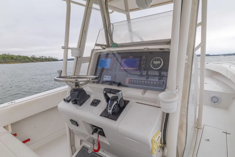 Slide: The Image of 2008 Jupiter 31 FS boat helm with modern navigation equipment on calm waters. - 32