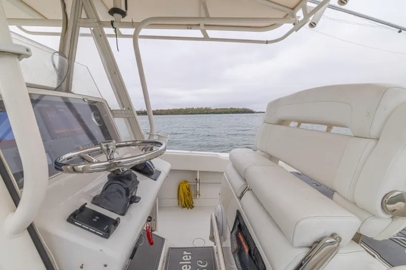 Slide: The Image of 2008 Jupiter 31 FS boat interior with steering wheel and seating, overlooking calm waters. - 34