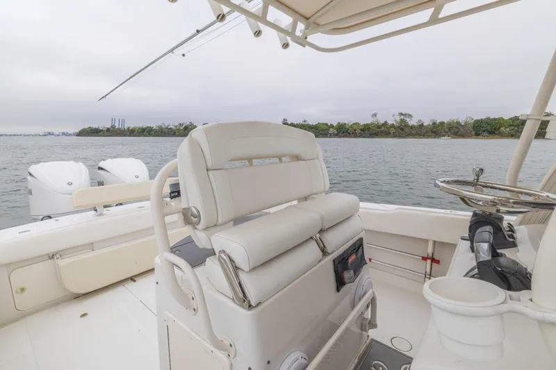 Slide: The Image of 2008 Jupiter 31 FS boat interior with dual engines, white seating, and ocean view. - 36