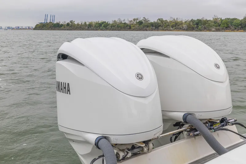 Slide: The Image of Twin Yamaha outboard engines on a 2008 Jupiter 31 FS boat, cruising on a calm river. - 40