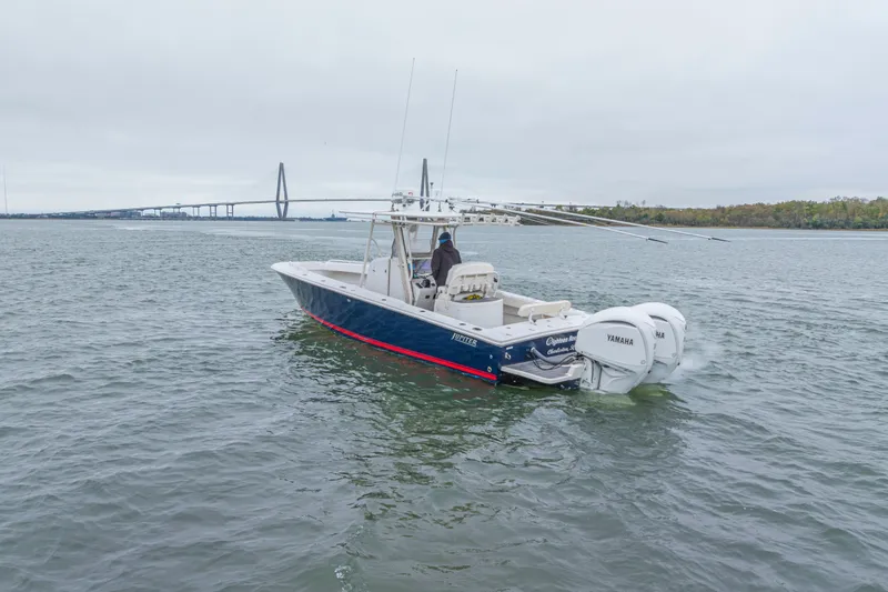 Slide: The Image of 2008 Jupiter 31 FS boat with twin Yamaha engines on open water near a bridge. - 5