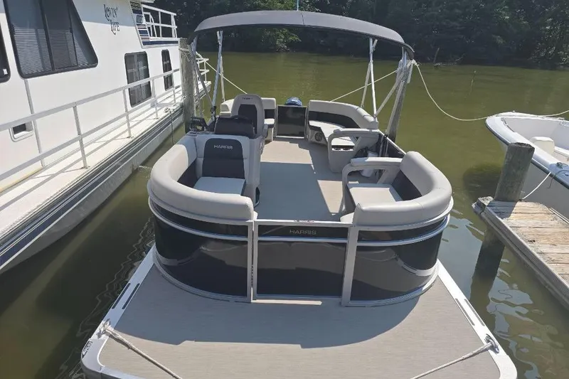 Slide: The Image of 2025 Harris Breeze 230 pontoon boat docked on a sunny day. - 6