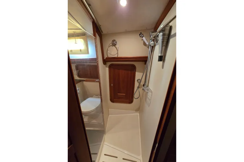 Slide: The Image of 2004 Legacy Yachts Sedan Flybridge bathroom with shower, wooden accents, and modern fixtures. - 18