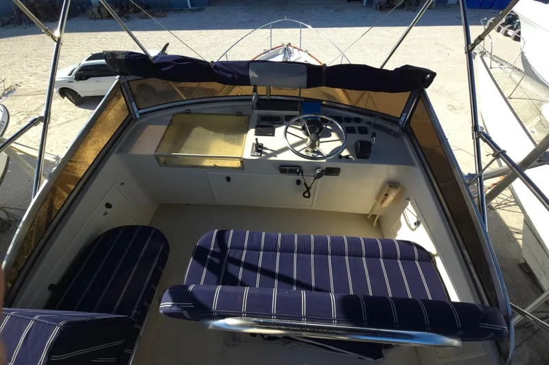 Slide: The Image of 2004 Legacy Yachts Sedan Flybridge helm with striped seating and steering wheel. - 22