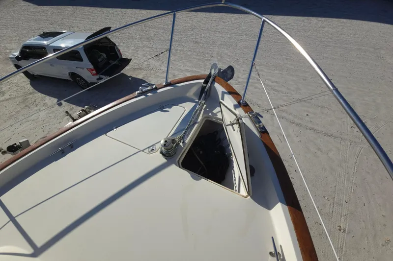 Slide: The Image of 2004 Legacy Yachts Sedan Flybridge bow with anchor, parked SUV nearby on sandy ground. - 26