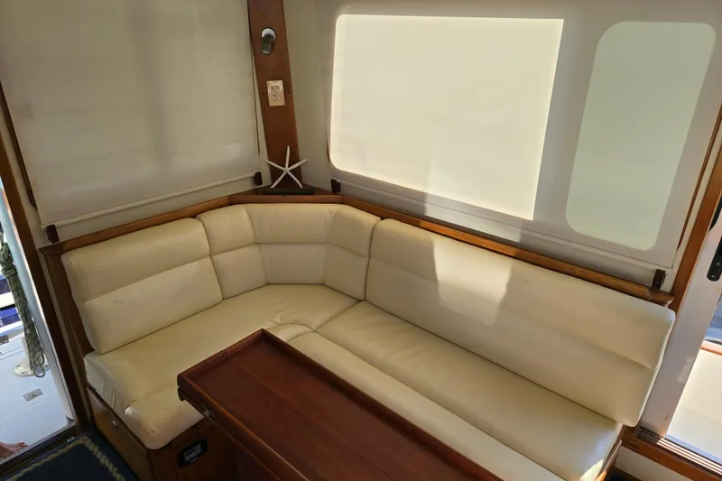 Slide: The Image of Luxurious interior of 2004 Legacy Yachts Sedan Flybridge with cream seating and wooden accents. - 4