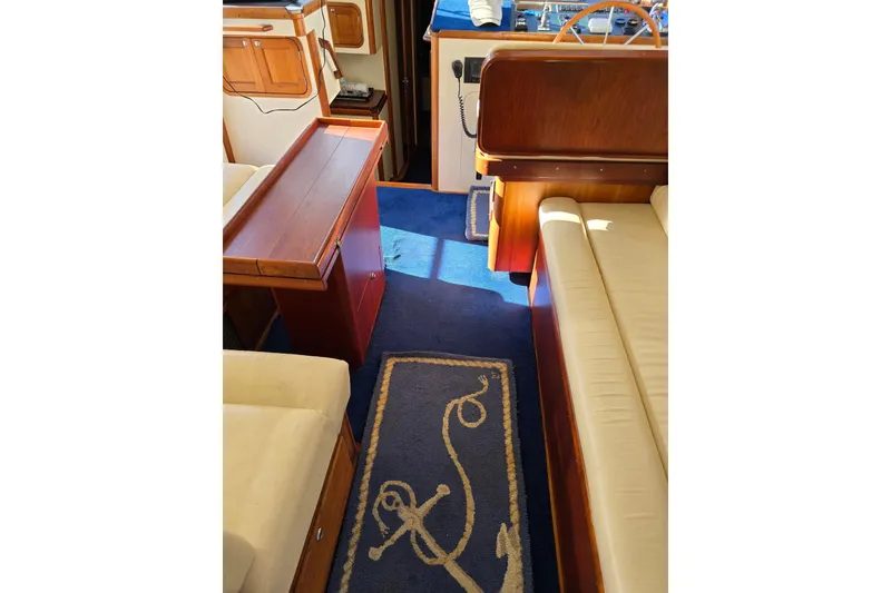 Slide: The Image of Interior of 2004 Legacy Yachts Sedan Flybridge with blue carpet and wooden furnishings. - 5