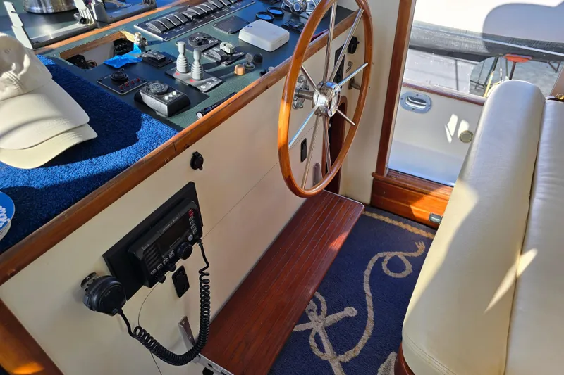 Slide: The Image of 2004 Legacy Yachts Sedan Flybridge helm with wooden steering wheel and navigation controls. - 6