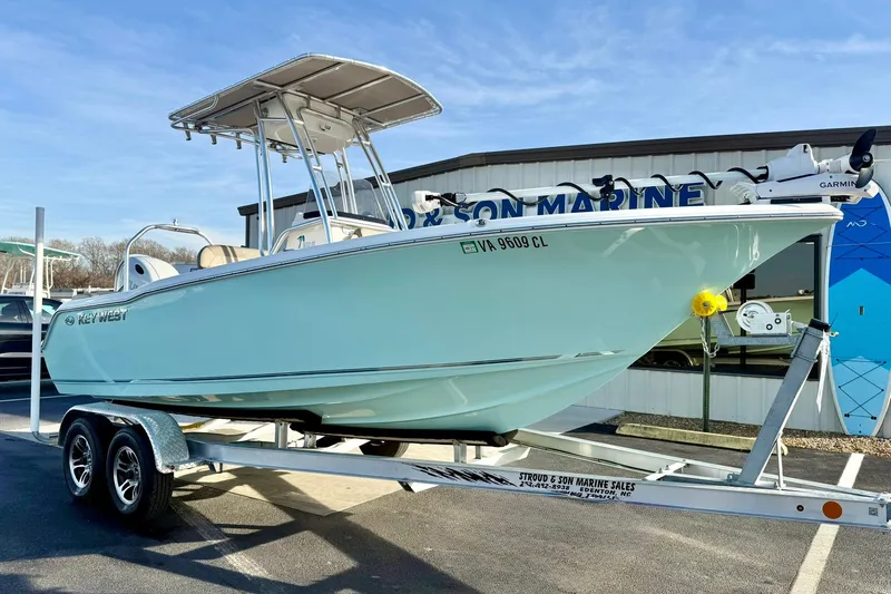 The Image of 2024 Key West 203 FS boat on trailer at dealership, sunny day. - 1