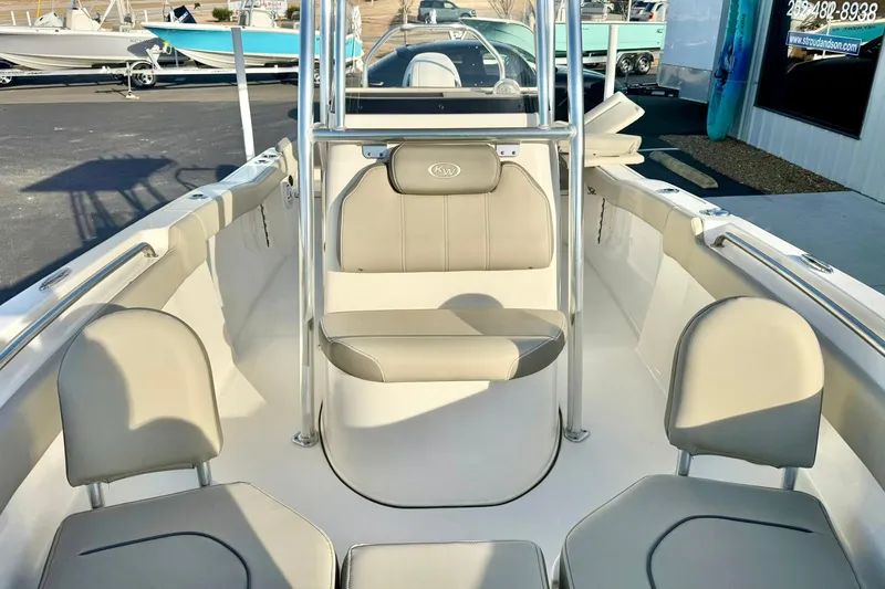 Slide: The Image of 2024 Key West 203 FS boat interior with seating and console, displayed outdoors. - 15