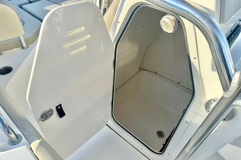 Slide: The Image of 2024 Key West 203 FS boat storage compartment with open hatch and stainless steel railing. - 22