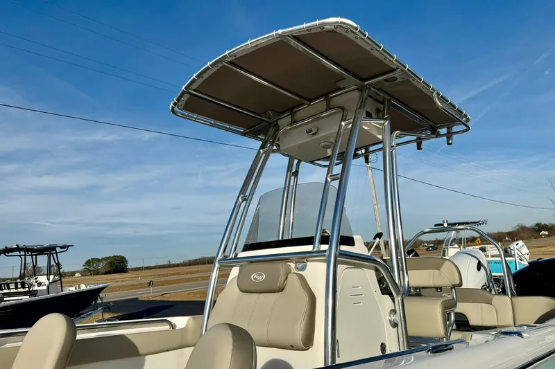 Slide: The Image of 2024 Key West 203 FS boat with T-top and seating, under clear blue sky. - 35