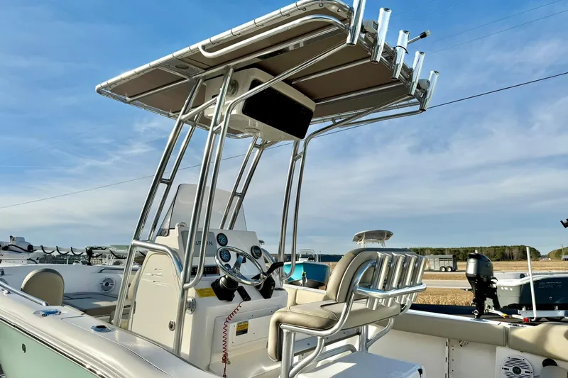 Slide: The Image of 2024 Key West 203 FS boat with T-top and seating, under a clear blue sky. - 38