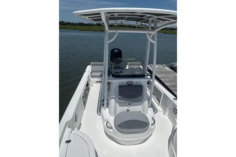 Slide: The Image of 2025 NauticStar 214 Shallow Bay boat on water, featuring center console and T-top. - 4