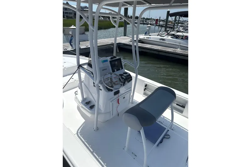 Slide: The Image of 2025 NauticStar 214 Shallow Bay boat interior with steering console and seating. - 5