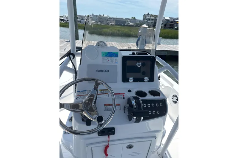 Slide: The Image of 2025 NauticStar 214 Shallow Bay boat console with steering wheel and navigation system. - 7