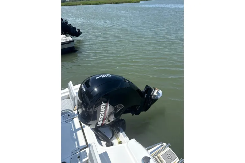 Slide: The Image of 2025 NauticStar 214 Shallow Bay with Mercury outboard motor on calm water. - 8