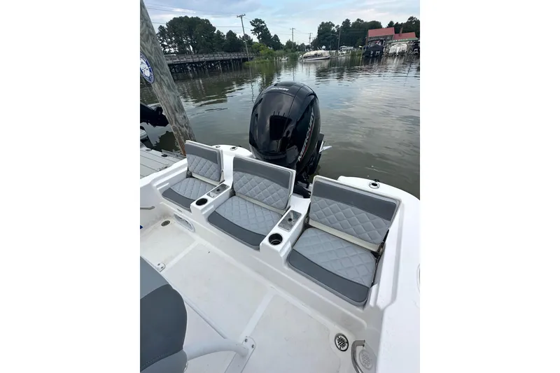 Slide: The Image of 2025 NauticStar 214 Shallow Bay boat with cushioned seating and outboard motor. - 10