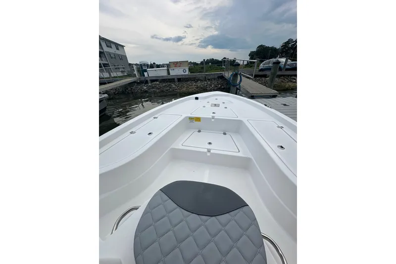 Slide: The Image of 2025 NauticStar 214 Shallow Bay boat interior at dock, featuring sleek seating and storage. - 4