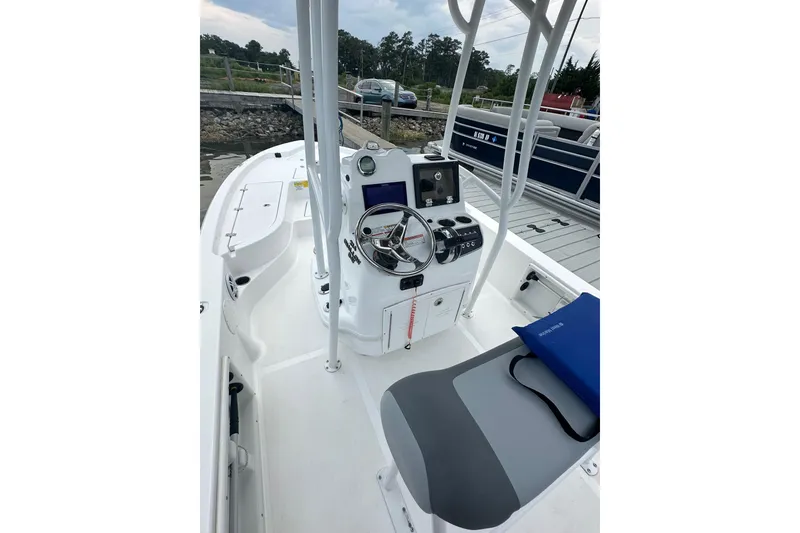 Slide: The Image of 2025 NauticStar 214 Shallow Bay boat interior with steering console and seating. - 5