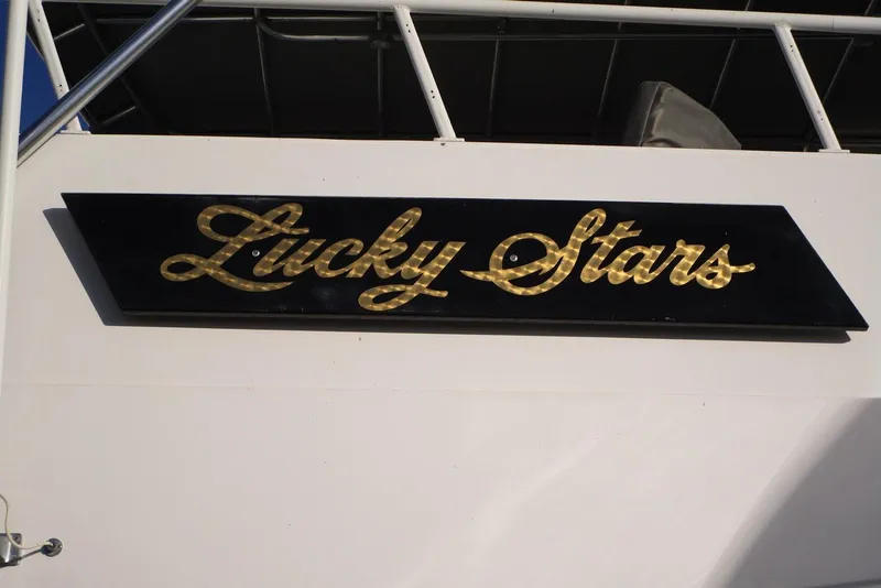 Slide: The Image of Gold "Lucky Stars" sign on 1990 Viking 72 Cockpit Motor Yacht. - 73