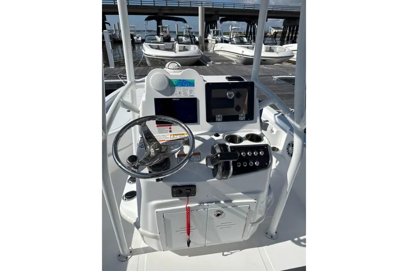 Slide: The Image of 2025 NauticStar 214 Shallow Bay boat console with steering wheel and navigation controls. - 4
