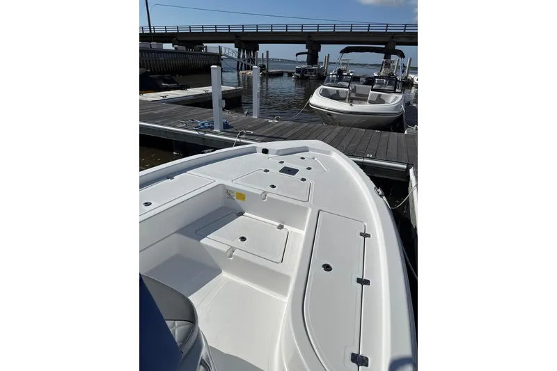 Slide: The Image of 2025 NauticStar 214 Shallow Bay boat docked at marina under bridge. - 5