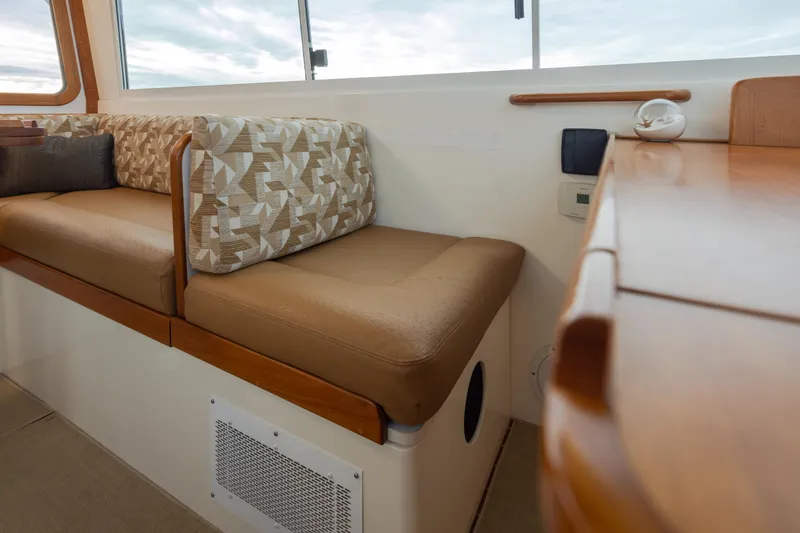 Slide: The Image of Interior of 2007 Bruckmann BLUESTAR boat with cushioned seating and wooden accents. - 12