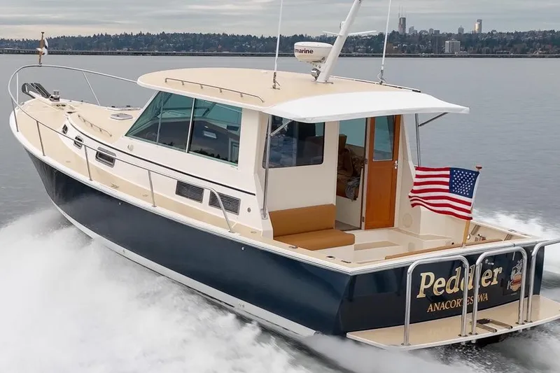 Slide: The Image of 2007 Bruckmann BLUESTAR boat cruising with American flag, scenic waterfront background. - 2